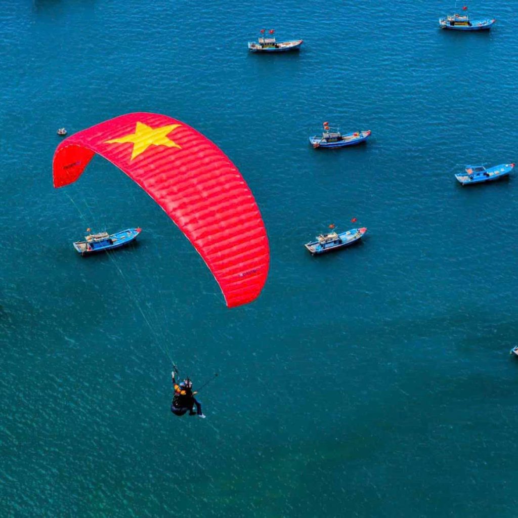Tandem paragliding in Da Nang with a view of the ocean and city skyline