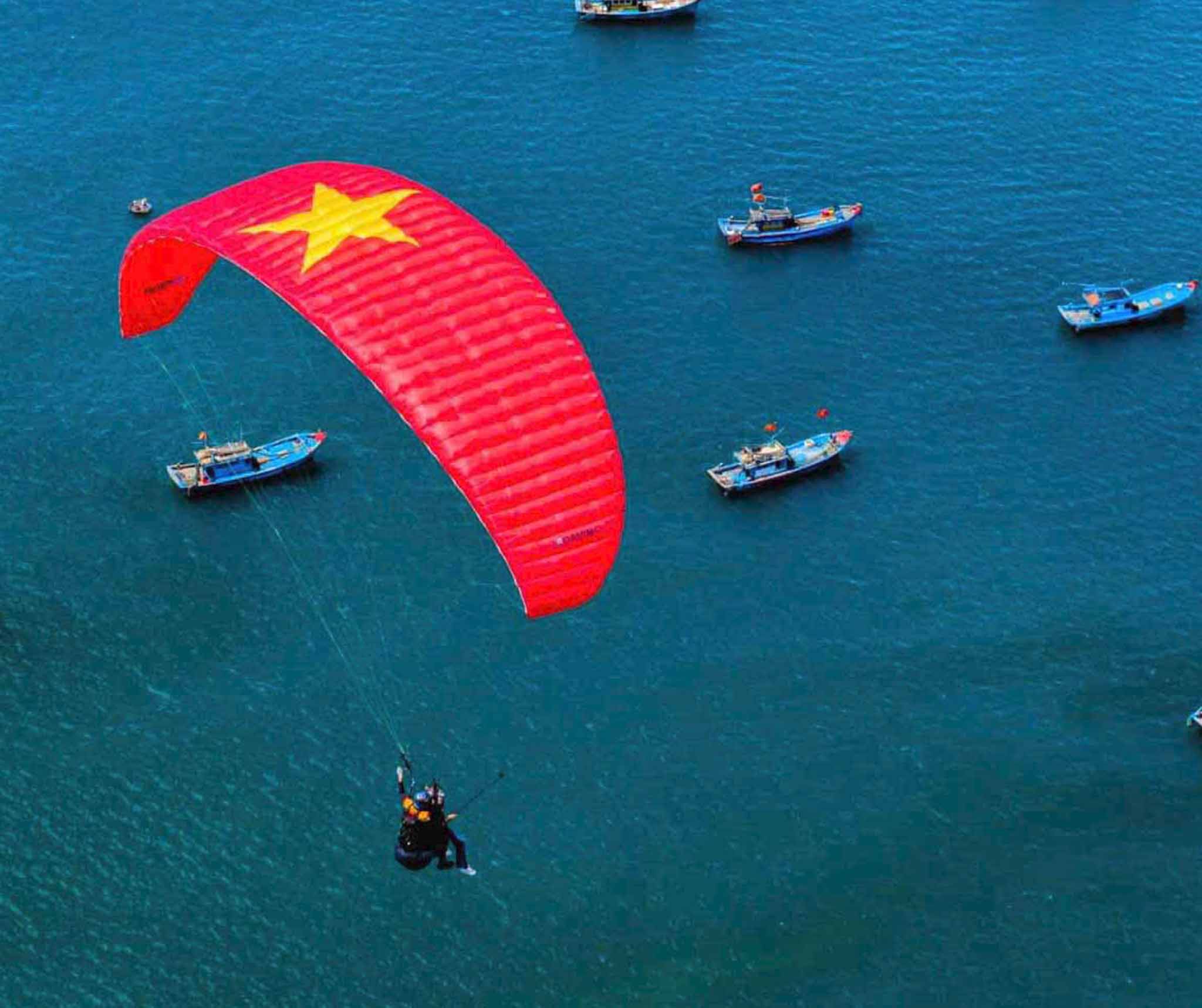 Tandem paragliding in Da Nang with a view of the ocean and city skyline